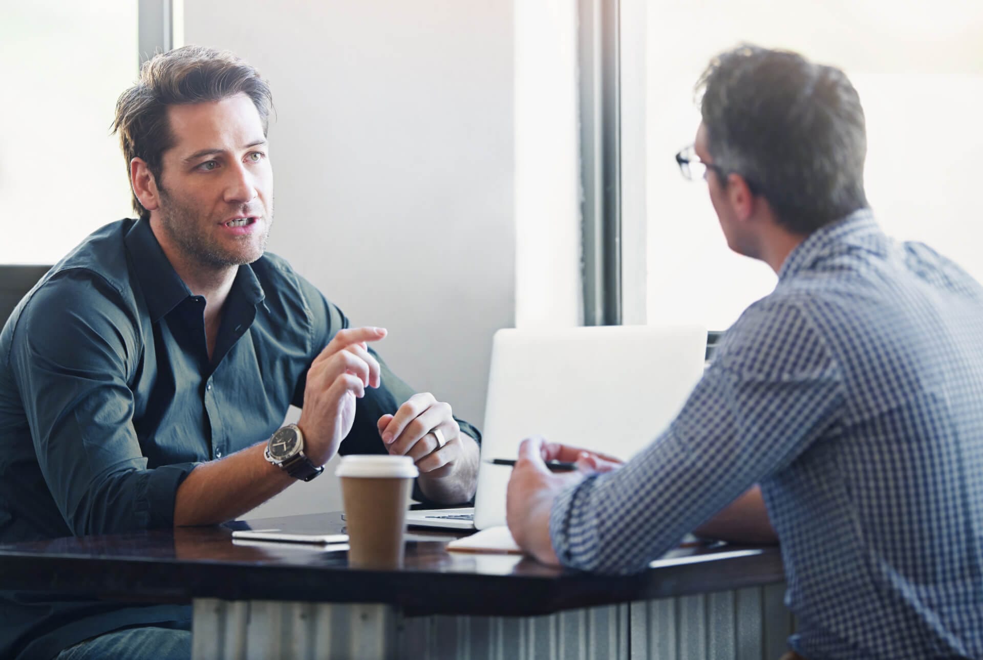 Ein Mentor spricht mit seinem Kollegen bei einem Kaffee in einer Mentoring Session