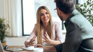 Ein Mann hört empathisch und ohne Vorurteile seinr Kollegin zu, die begeistert ihre Idee erklärt. Symbolisch dafür, wie Empathie & Impathie die Resilienz stärken kann.