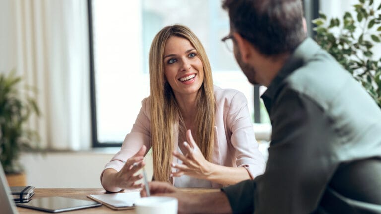 Ein Mann hört empathisch und ohne Vorurteile seinr Kollegin zu, die begeistert ihre Idee erklärt. Symbolisch dafür, wie Empathie & Impathie die Resilienz stärken kann.