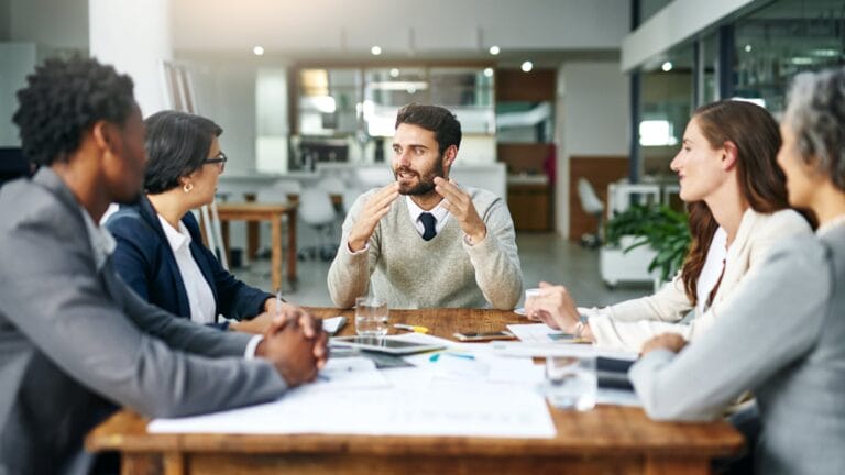 Ein Teamleiter spricht mit seinem Team. Symbolisch für Führungskräfte-Coaching bei proCEO.