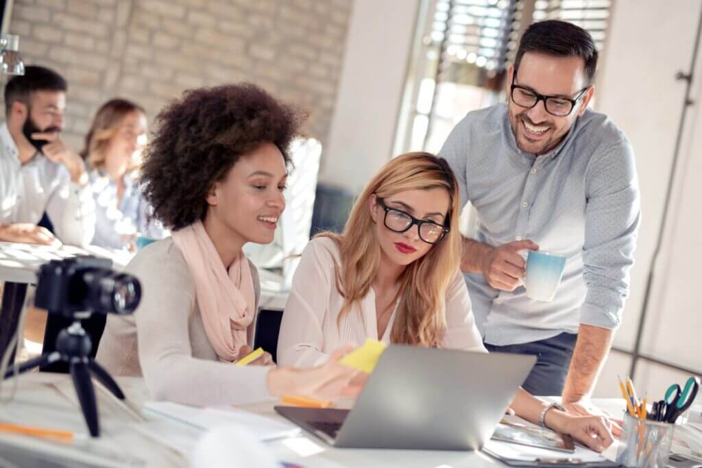 Zwei Kolleginnen und ihr Kollege erarbeiten gemeinsam eine Projektstrategie.