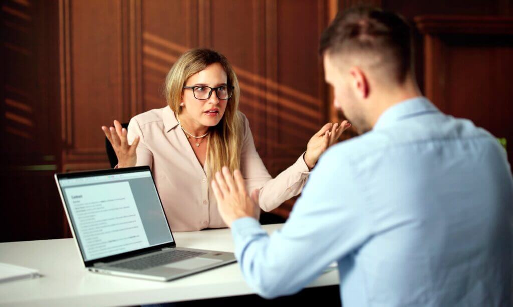 Ein Mann reagiert entspannt, der von seiner Kollegin konfrontiert wird. Symbolisches Bild f&uuml;r Achtsamkeit und Ver&auml;nderung von Handlungsmustern.