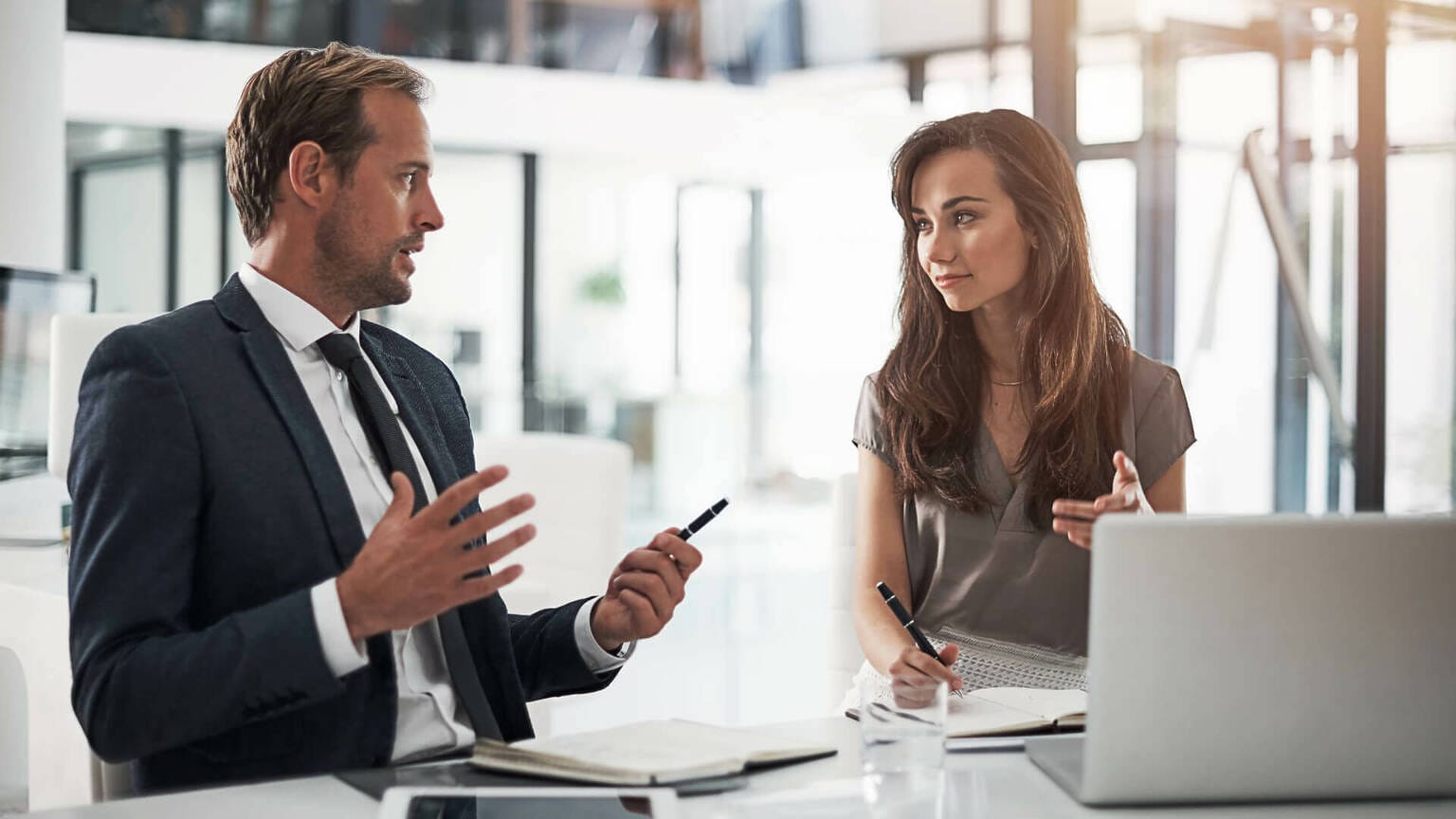 Ein Geschäftsmann und eine Geschäftsfrau sprechen während einer Mentoring Session. Symbolisches Bild für Mentoring in Nürnberg, Fürth, Erlangen und Online.
