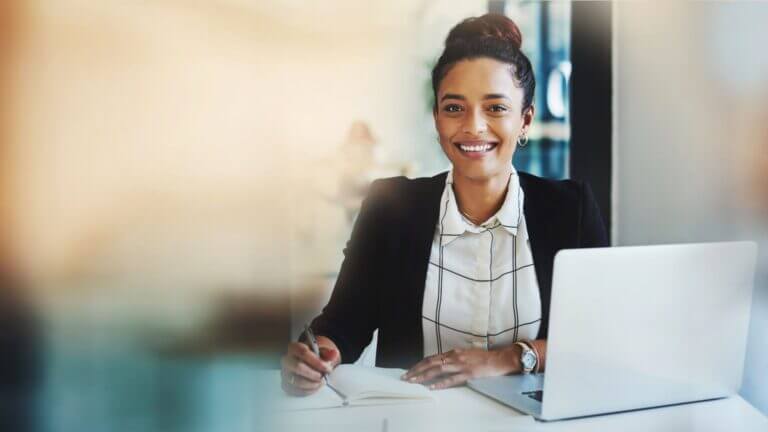 Eine junge Frau plant ihre Aufgaben mit Notizblock und Laptop. Symbolisches Bild für Selbstmanagement mit dem Zürcher Ressourcen Modell im Online-Seminar des proCEO Online CAMPUS.