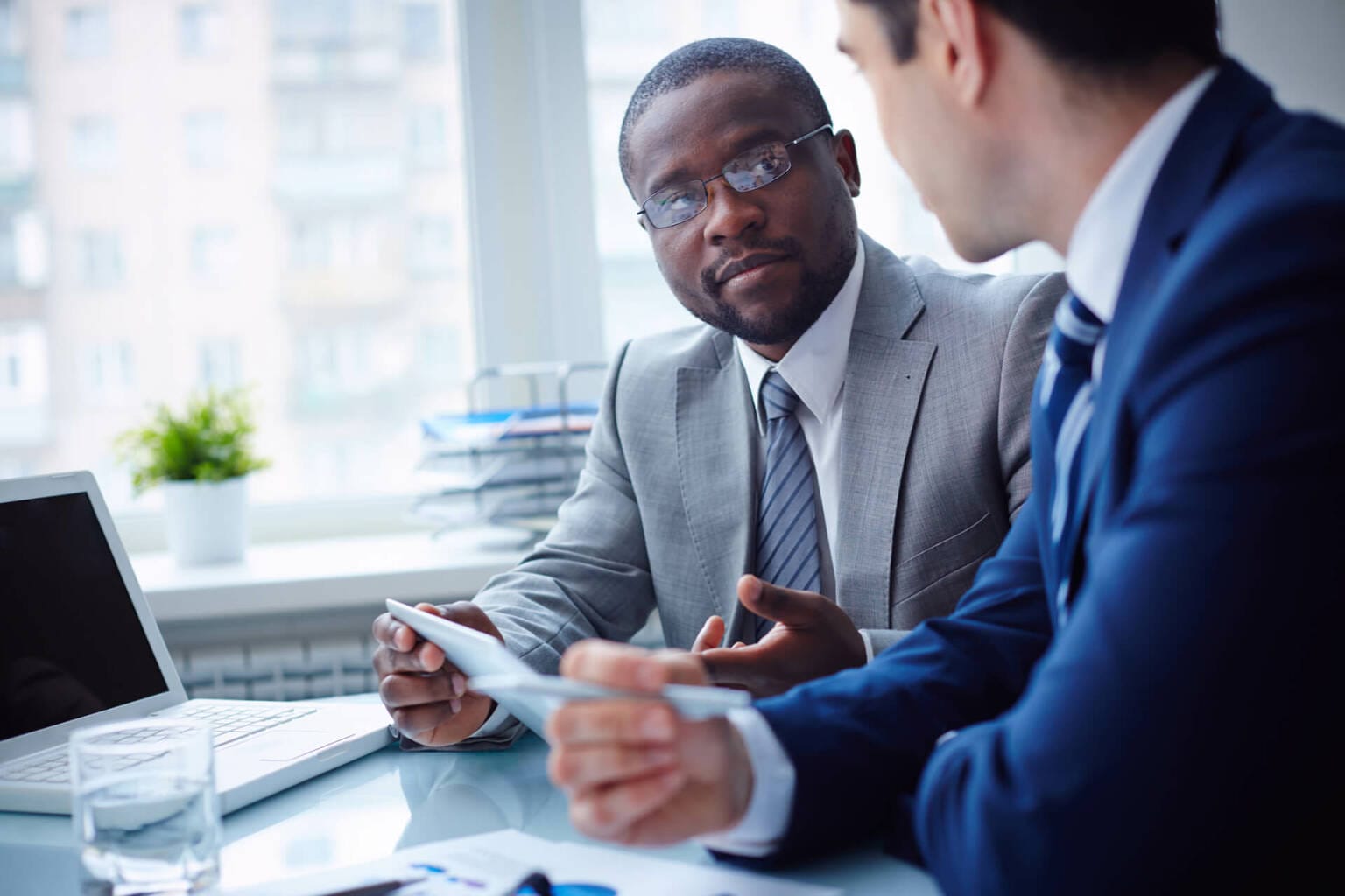 Ein Berater spricht mit einem Mitarbeiter im Rahmen einer Organisationsberatung. Symbolisches Bild für professionelle Organisationsberatung im Raum Nürnberg, Fürth, Erlangen und Online.