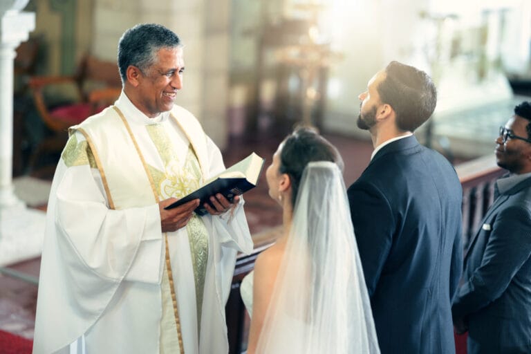 Ein Pfarrer steht vor einem Brautpaar in der Kirche. Sinnbild für eine Supervision Ausbildung für Mitarbeitende in kirchlichen und religiösen Organisationen.